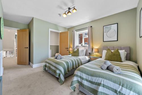 Ένα ή περισσότερα κρεβάτια σε δωμάτιο στο 5-Bedroom Stunning, Luxurious & Stylish Manor with Games Room, Private Parking & Garden, Central Gloucester, Cotswolds Retreat Sleeps up to 12 - WORK CONTRACTORS SPECIAL OFFER! - by Blue Puffin Stays