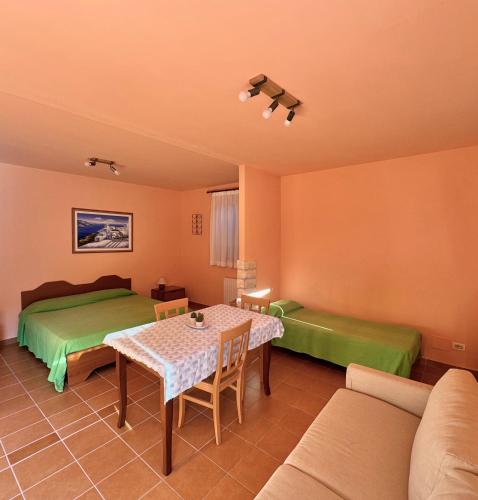 a room with two beds and a table and a couch at Alloggio Agrituristico Ronchi Di Fornalis in Cividale del Friuli