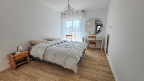 une chambre avec un lit, une table et un miroir dans l'établissement Charmant T3 au Mourillon, à Toulon