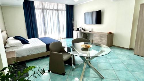 a hotel room with a bed and a glass table at Hotel Centro Congressi Polo Nautico in Salerno