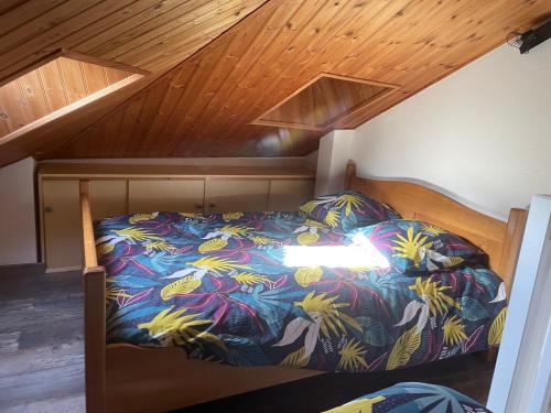 un lit avec une couette colorée dans une chambre dans l'établissement appartement vue mer sur la corniche ST Hilaire de riez résidence Sémaphore, à Saint-Hilaire-de-Riez