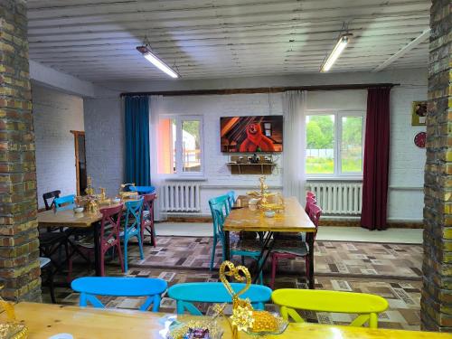 a restaurant with tables and chairs and a painting on the wall at Kolsay Aisha in Saty
