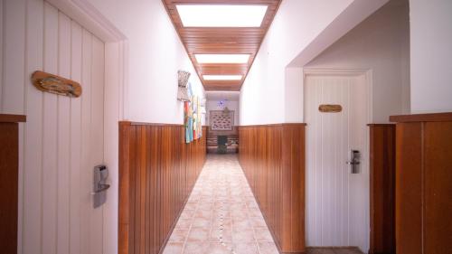 a hallway of a building with wooden doors and a ceiling at Pousada Montão do Trigo Juquehy in Juquei