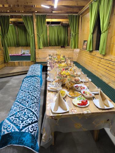 a long table with plates of food on it at Kolsay Aisha in Saty