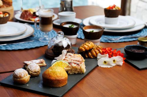a table topped with plates of food on a table at Almareia Boutique Hotel in Praia dos Carneiros