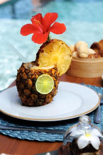 a pineapple with a flower on top of it on a plate at Almareia Boutique Hotel in Praia dos Carneiros