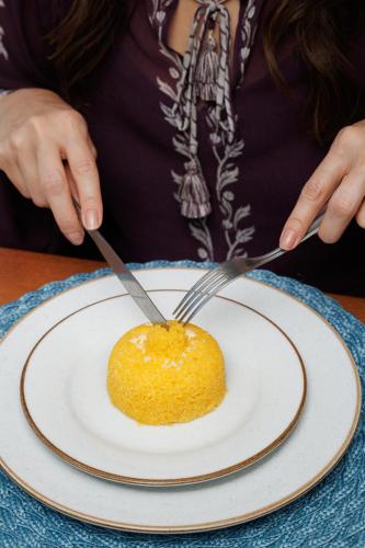 a person cutting a piece of cake on a plate at Almareia Boutique Hotel in Praia dos Carneiros