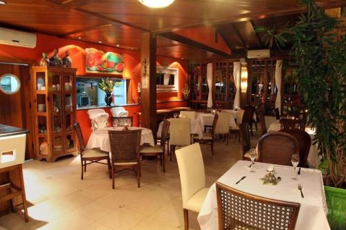 a restaurant with tables and chairs in a room at Pousada Montão do Trigo Juquehy in Juquei