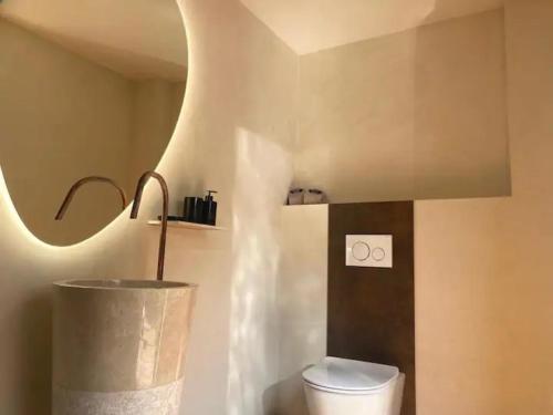 une salle de bain avec toilettes et une lumière au mur dans l'établissement La Saint Pabu'lle, à Pléneuf-Val-André