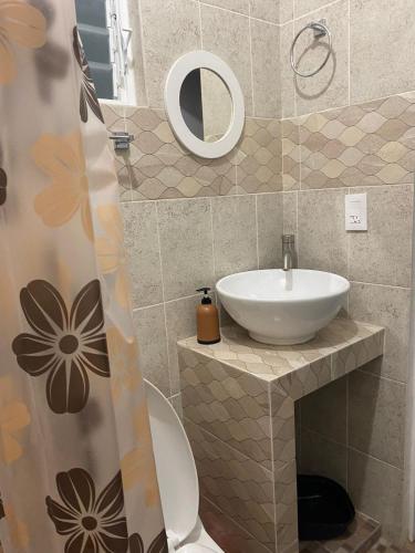 a bathroom with a sink and a toilet and a mirror at Casa Ba-Al, Bonito departamento a 5 minutos del centro de Oaxaca in Oaxaca City