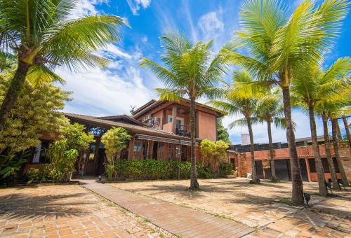a group of palm trees in front of a building at Pousada Montão do Trigo Juquehy in Juquei