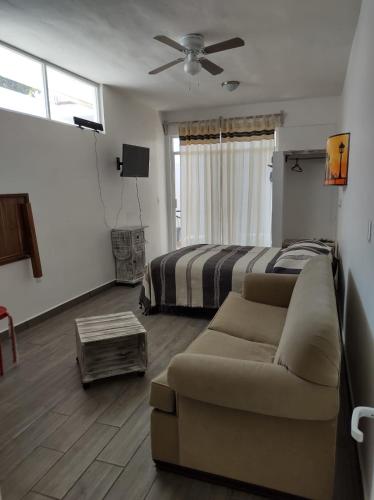 a living room with a couch and a bed at Casa Ba-Al, Bonito departamento a 5 minutos del centro de Oaxaca in Oaxaca City