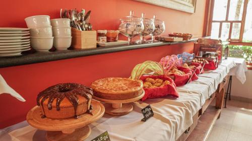 a table with bread and other pastries on it at Pousada Montão do Trigo Juquehy in Juquei