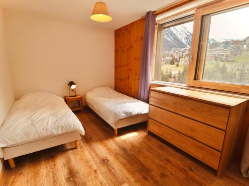 une chambre avec deux lits et une commode et une fenêtre dans l'établissement Spacieux Appartement 2* près des pistes et du centre station - Courchevel Village - FR-1-514-41, à Courchevel