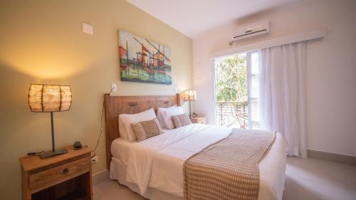 a bedroom with a large bed and a window at Pousada Montão do Trigo Juquehy in Juquei