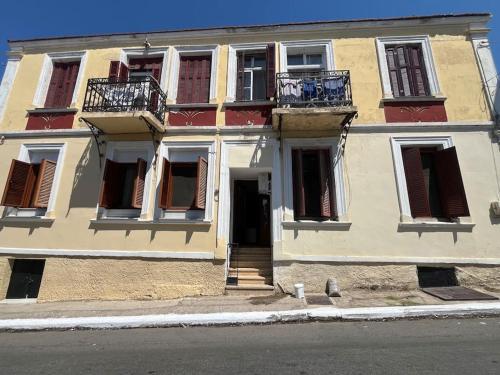 a building with balconies and a door on a street at Kona Apt Limenaria Thasos in Limenaria