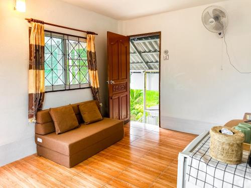 a living room with a couch and a window at Ao Luek Homie Homestay in Krabi town