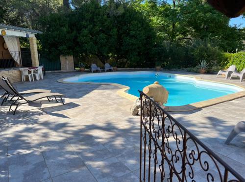 une petite piscine avec des chaises et une clôture dans l'établissement Entre mer et Pic Saint Loup, à Grabels