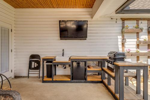 a patio with two tables and a television on a wall at Piney Cove Retreat in West Monroe