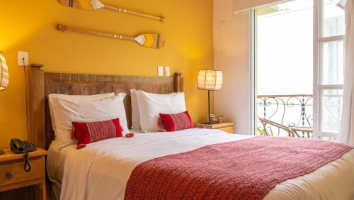 a bedroom with a large bed with red and white pillows at Pousada Montão do Trigo Juquehy in Juquei