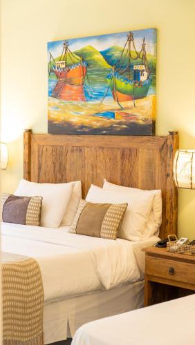 two beds in a room with a painting on the wall at Pousada Montão do Trigo Juquehy in Juquei