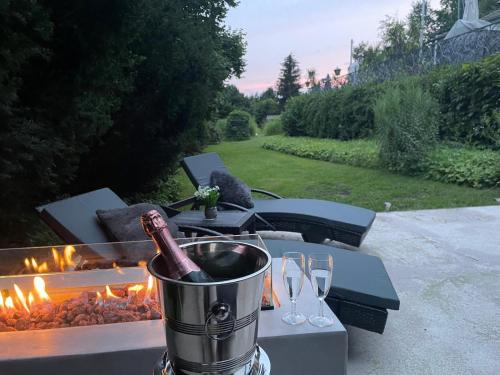 a table with a bucket of wine and wine glasses at Moderne Ferienwohnung in Waldrandlage mit einem Hauch von Luxus in Burgthann