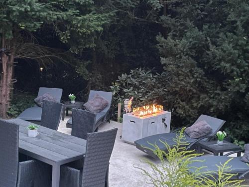 a patio with a table and chairs and a fire pit at Moderne Ferienwohnung in Waldrandlage mit einem Hauch von Luxus in Burgthann
