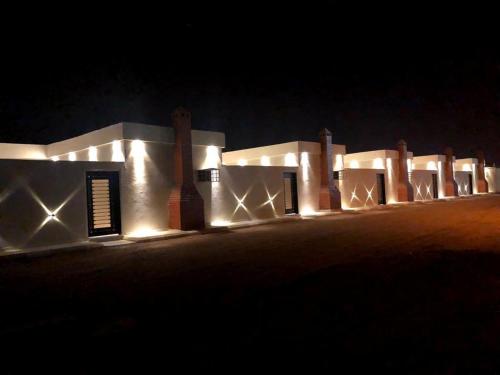 ein weißes Gebäude mit Lichtern in der Nacht in der Unterkunft تذكار in Bisha