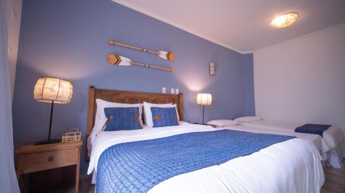 a bedroom with a large bed with blue walls at Pousada Montão do Trigo Juquehy in Juquei