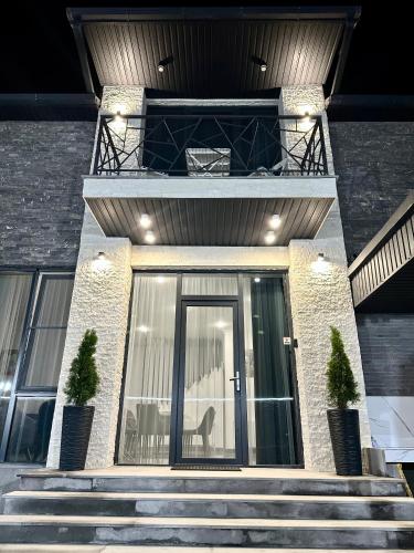 a house with a glass door and stairs at Batikyans' Villa Tsaghkadzor in Tsaghkadzor
