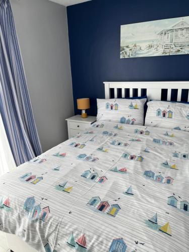 a bedroom with a bed with a bedspread with boats on it at 114 Bermuda in Hemsby