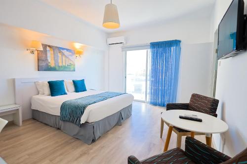 a hotel room with a bed and a table at Mikes Kanarium City Hotel in Larnaka
