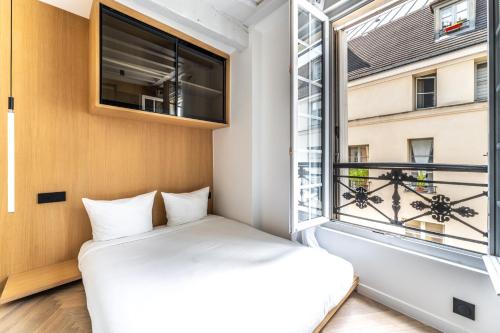 une chambre avec un lit et une fenêtre dans l'établissement Le Chic Marais Parisien, à Paris