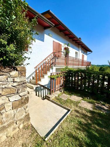 a house with a staircase and a porch with a fence at Alloggio Agrituristico Ronchi Di Fornalis in Cividale del Friuli
