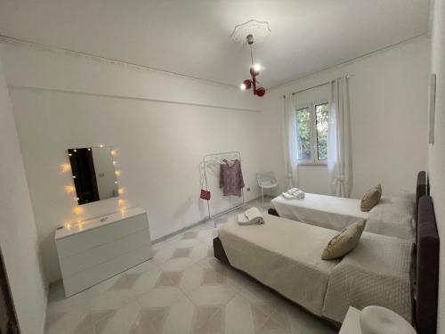 a white room with two beds and a television at Casa Vacanze Villa Lena in Santa Flavia