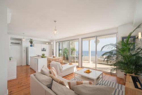 a living room with white furniture and a view of the ocean at Casa Mar Dream House Old Town Funchal in Funchal