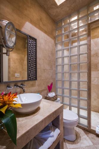 a bathroom with a sink and a toilet at Placencia Resort in Maya Beach