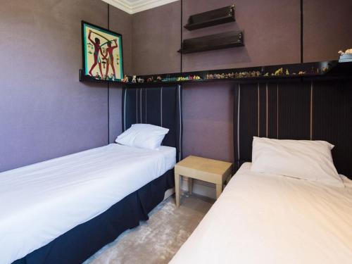 deux lits côte à côte dans une pièce dans l'établissement Charmante maison familiale avec jolie vue mer, à Villeneuve-Loubet