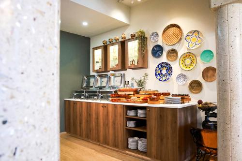 a kitchen with a counter with plates on the wall at Mikes Kanarium City Hotel in Larnaka