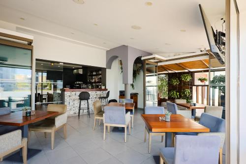 a restaurant with tables and chairs and a bar at Mikes Kanarium City Hotel in Larnaka
