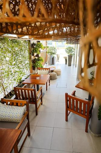 a patio with wooden tables and benches in a restaurant at Mikes Kanarium City Hotel in Larnaka
