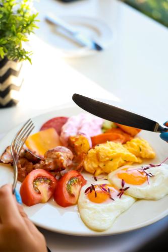 a plate of food with eggs and tomatoes on a table at Mikes Kanarium City Hotel in Larnaka