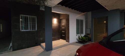 a red car parked in front of a house at night at Casa Cháak in Caucel