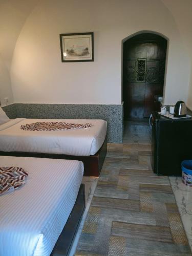 a room with two beds and a door at Dolphin Continental Hotel in Quseir