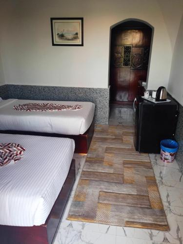 a room with two beds and a door at Dolphin Continental Hotel in Quseir