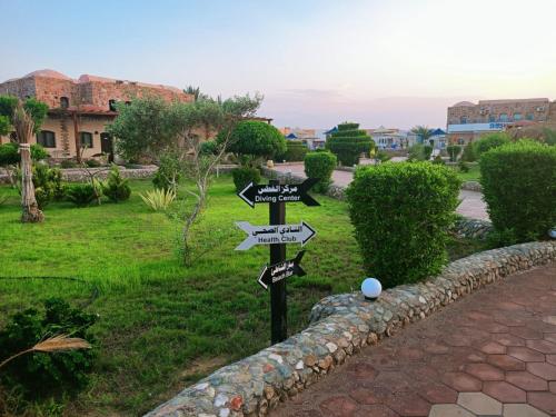 a street sign with arrows pointing in different directions at Dolphin Continental Hotel in Quseir