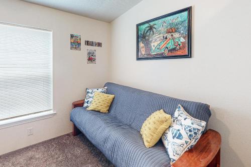 a living room with a blue couch and a window at Reedsport Coastal Retreat in Reedsport