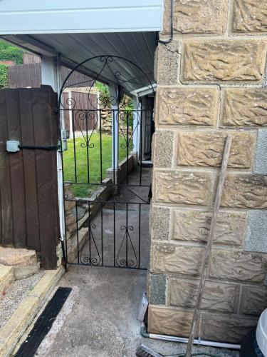an entrance to a driveway with a iron gate at Hillcrest Bungalow in Nottingham