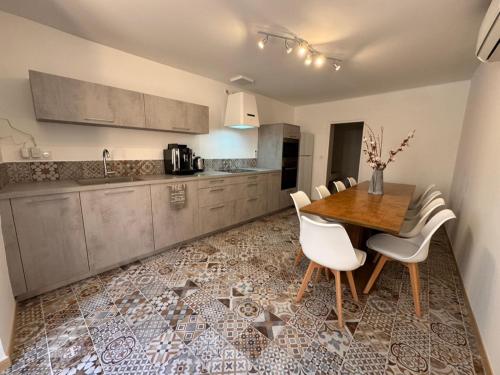 - une cuisine avec une table en bois et des chaises blanches dans l'établissement Le Buisson Caché, à Buisson