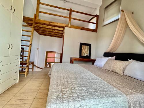 une chambre avec un grand lit et une chaise dans l'établissement Despoina's Maisonette at Rafaella Resort, à Kokóni